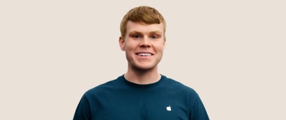 Retrato de una persona del equipo de Apple Retail sonriendo con cabello corto, rubio oscuro.