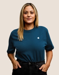 Retrato de una persona del equipo de Apple Retail sonriendo con cabello largo, rubio oscuro.