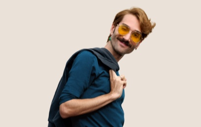 Retrato de una persona del equipo de Apple Retail sonriendo con cabello corto, rubio oscuro y lentes.