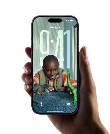 Egy felhasználó kezében tartott iPhone készüléken az új Liquid Glass dizájn dinamikusan hozzáigazítja az időkijelzést a zárolt képernyőn látható képhez